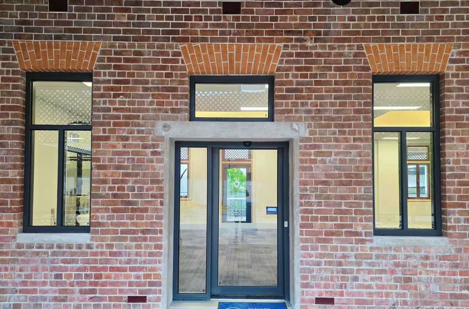Heritage brick facade with dark aluminium windows and entry door