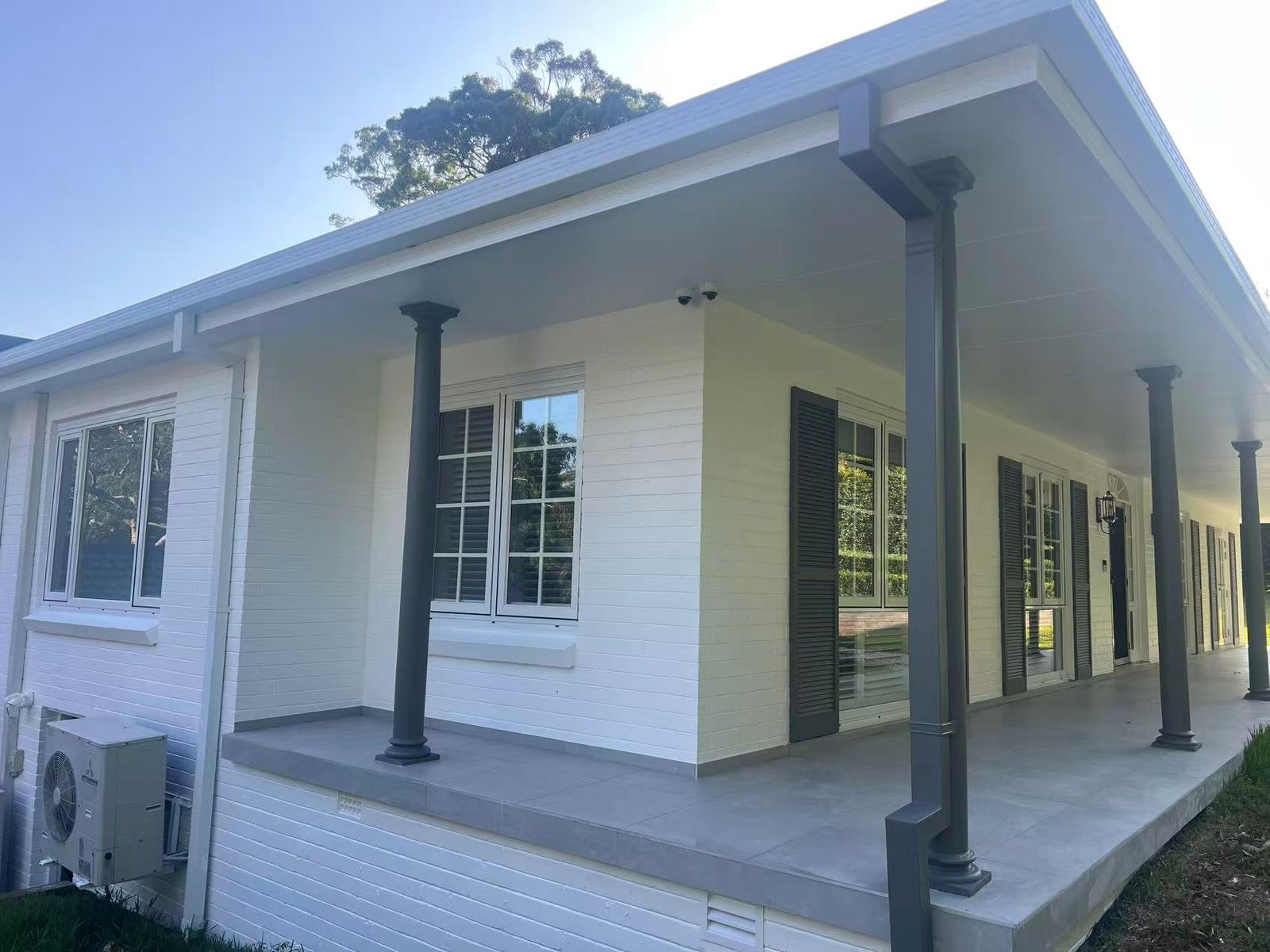 Verandah of colonial-style home with white aluminium windows