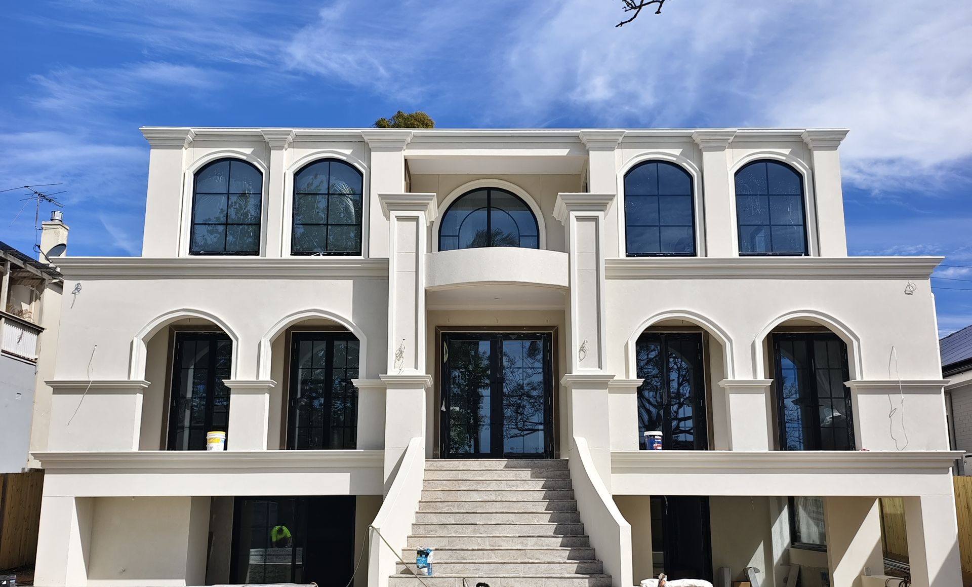 Two-storey French-style residence in Roseville NSW with black arched aluminium windows and French doors by ANZWIN